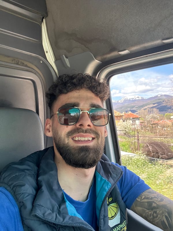 Smiling bearded man observed in vehicle wearing blue clothing