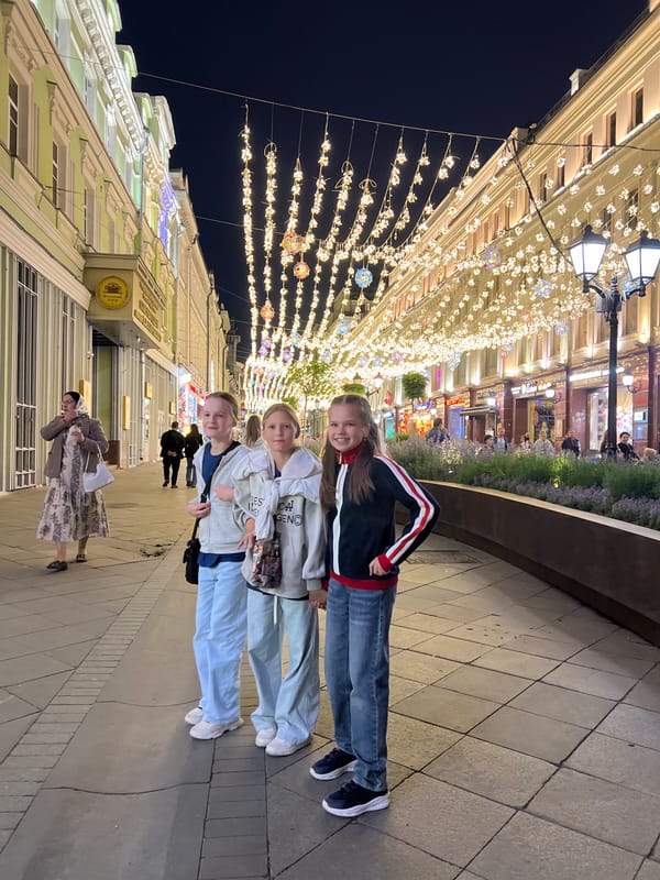 Evening street life in illuminated Moscow pedestrian area