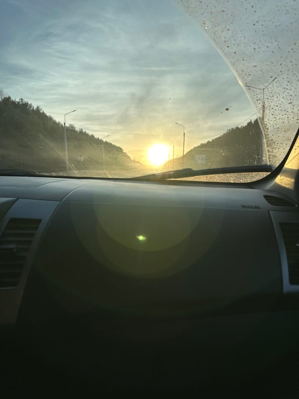 Vehicle travels rural road during sunset in Shud'ya, Russia