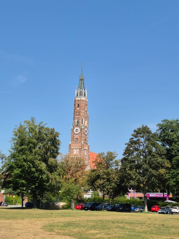 Landshut's Gothic church tower and hilltop castle on a sunny afternoon
