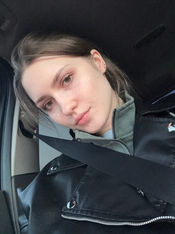 Woman takes selfies in car mirror during traffic jam