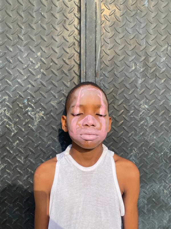 Children with pink face paint photographed in Iranla, Nigeria