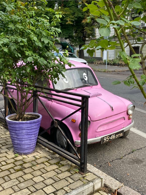 Quirky street décor — googly-eyed car and painted generator on the sidewalk