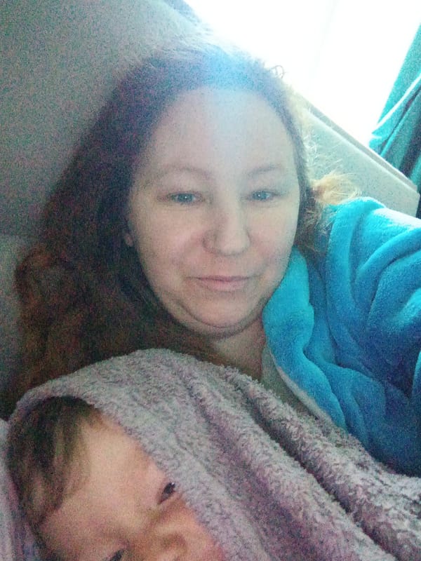 Casual selfie moment with a baby in a blue robe