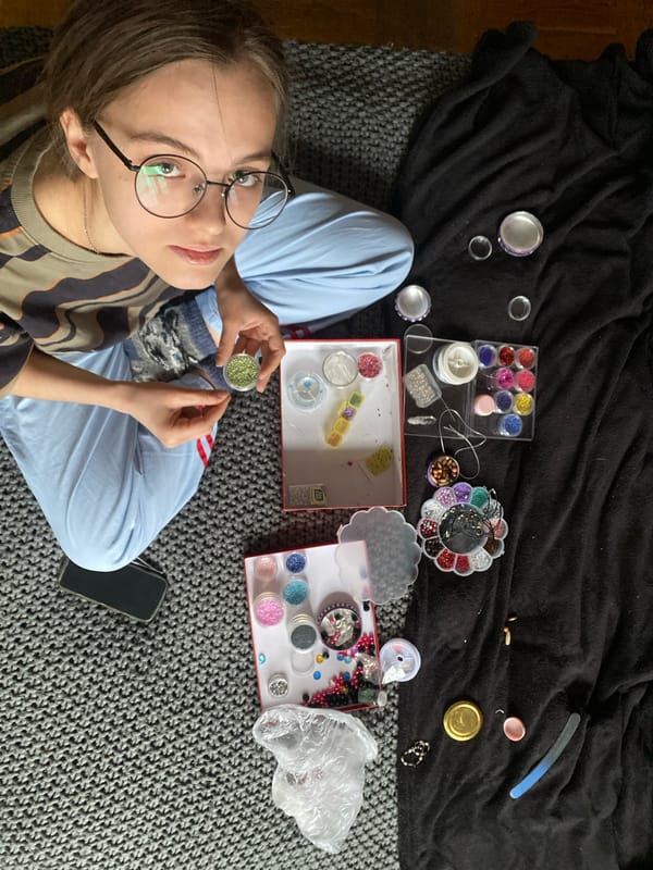 Person crafts beaded lanyard in Moscow park afternoon