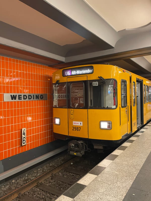 Yellow U6 subway train stops at Berlin station with passengers