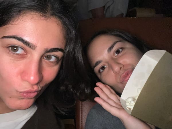 Two women share movie snacks at Paris Pathé cinema