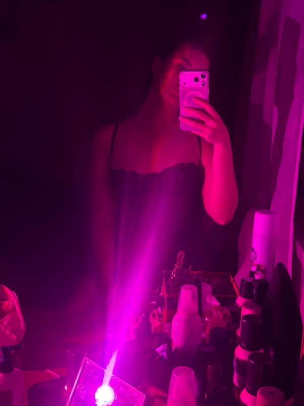 Woman takes selfies in pink-lit Moscow room