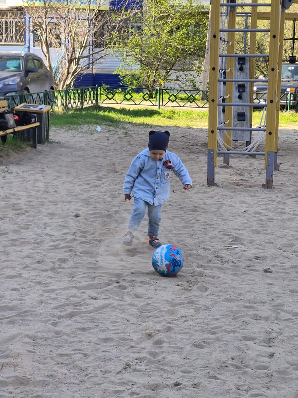 Child plays ball, woman takes selfie in Tobolsk playground area