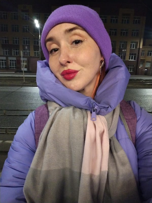 Woman takes nighttime selfie on Izhevsk sidewalk