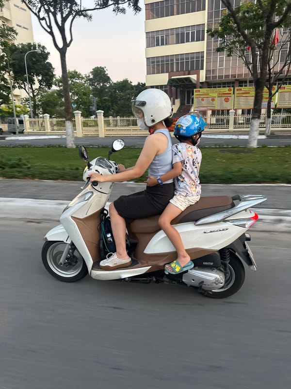 Adult and child ride scooter together in Đà Nẵng