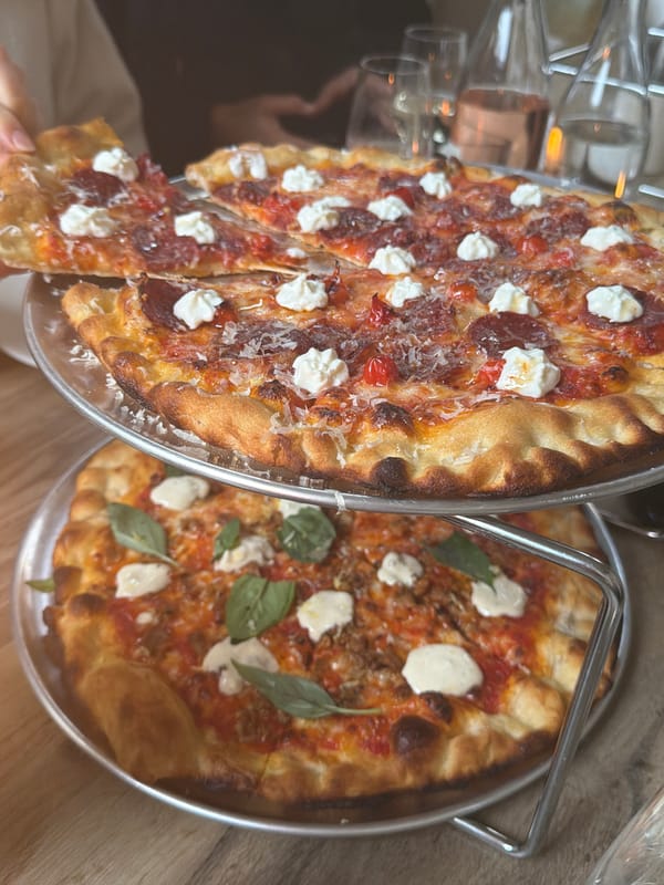 Women share pizza and wine at restaurant gathering