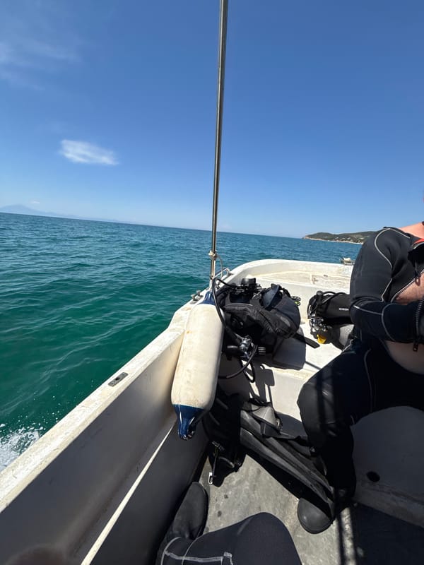 Scuba divers heading out on calm Aegean waters near Limenaria