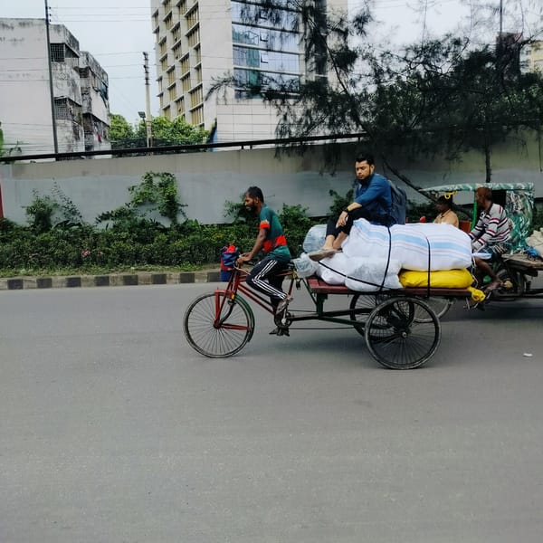 AC repair and street work on a Dhaka morning