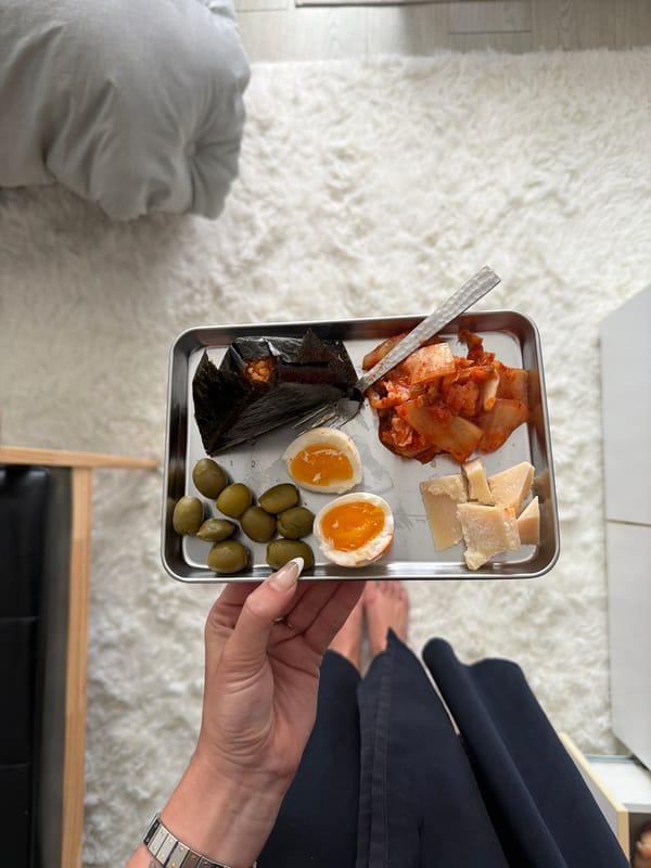 Woman holds food tray with kimchi, eggs in Seoul