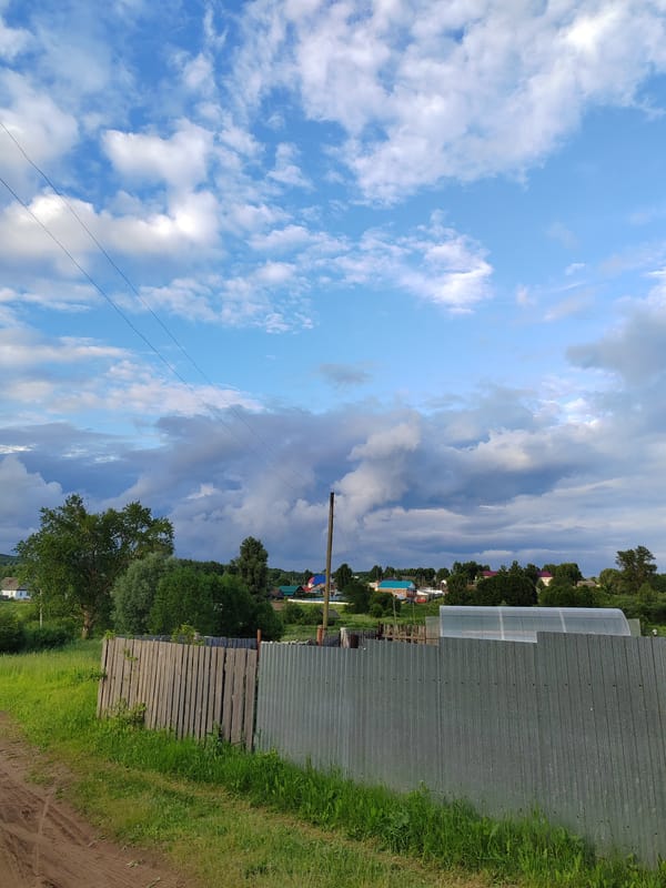 Rural countryside drive through fields and villages under stormy skies