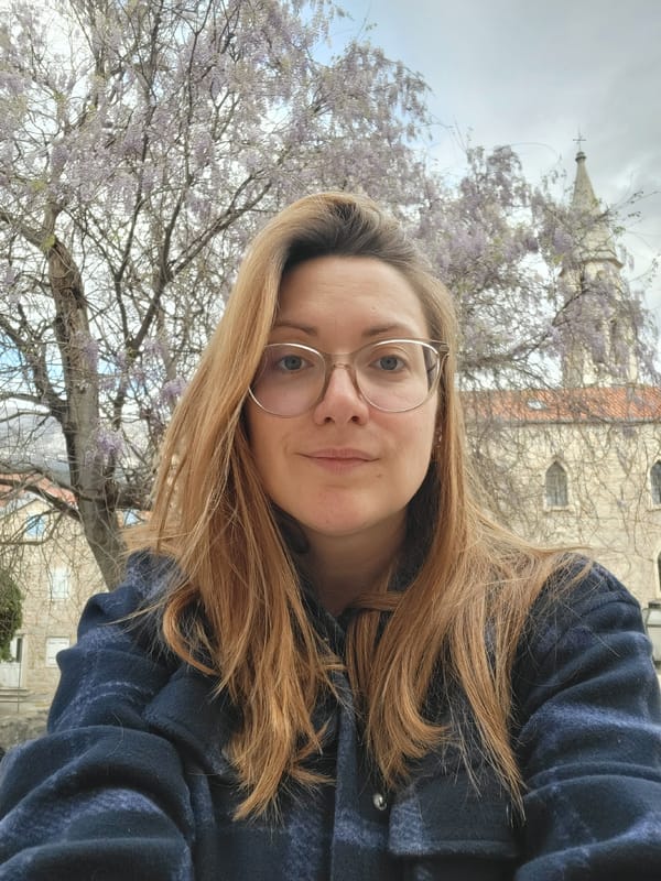 Tourist with dog explores historic Budva amid spring blooms