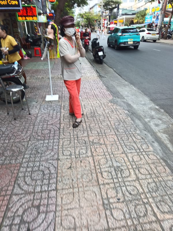 Morning street life along a Nha Trang commercial sidewalk