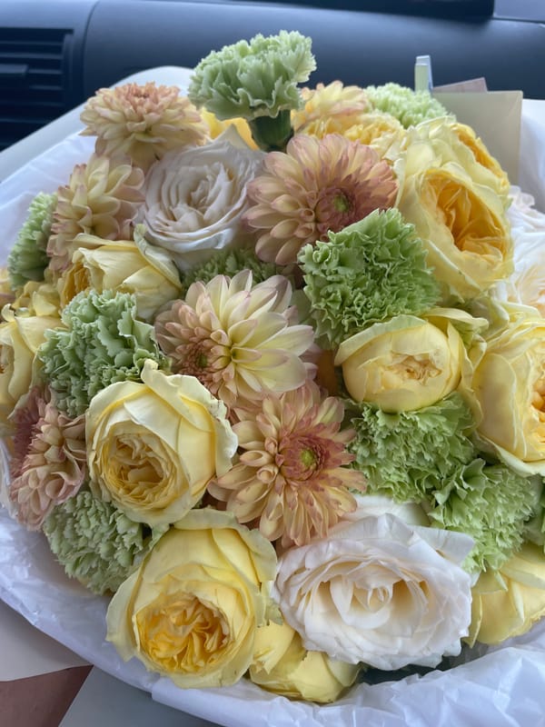 Mixed bouquet of roses and dahlias, wrapped and ready to go
