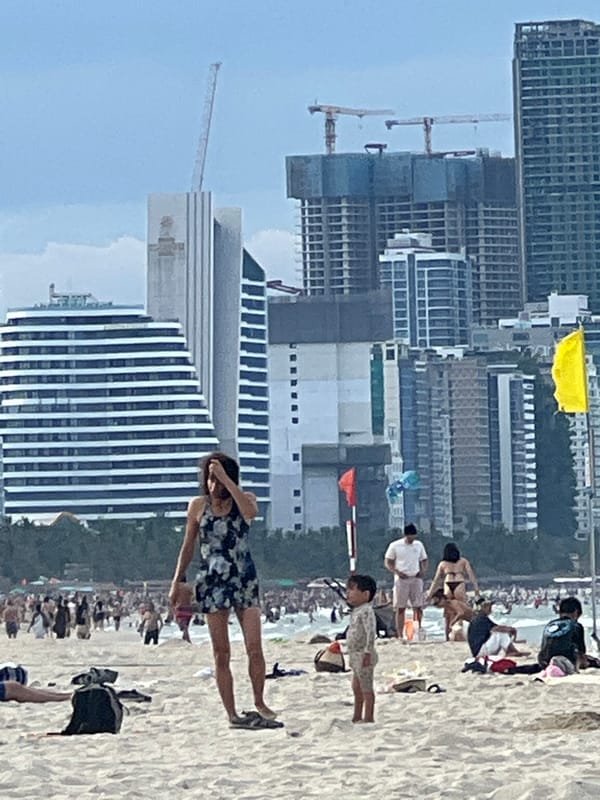 Busy morning at Đà Nẵng's Mỹ Khê Beach under cloudy skies