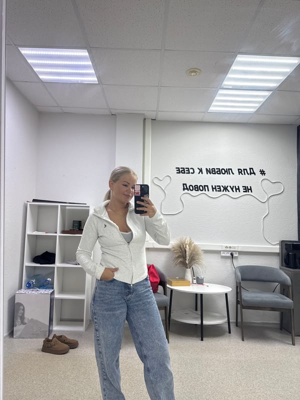Woman takes morning mirror selfie in beige robe