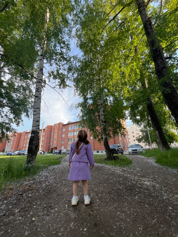 Young girl drives red toy Mercedes in outdoor setting