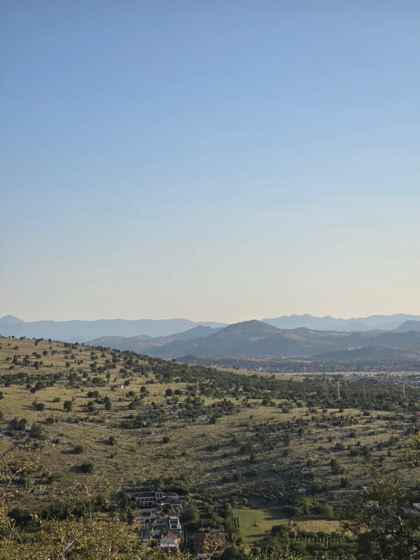 Hilly landscape with monuments, flags, and rural infrastructure