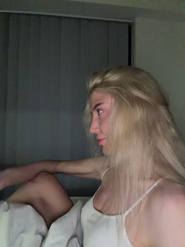 Woman sits in bedroom during evening hours in Belgrade