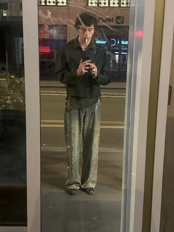 Man smoking cigarette views reflection on Paris street