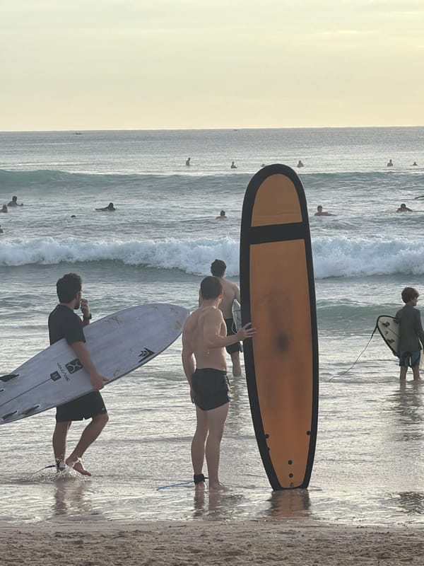 Surfers gather with boards at Kuta Selatan beach
