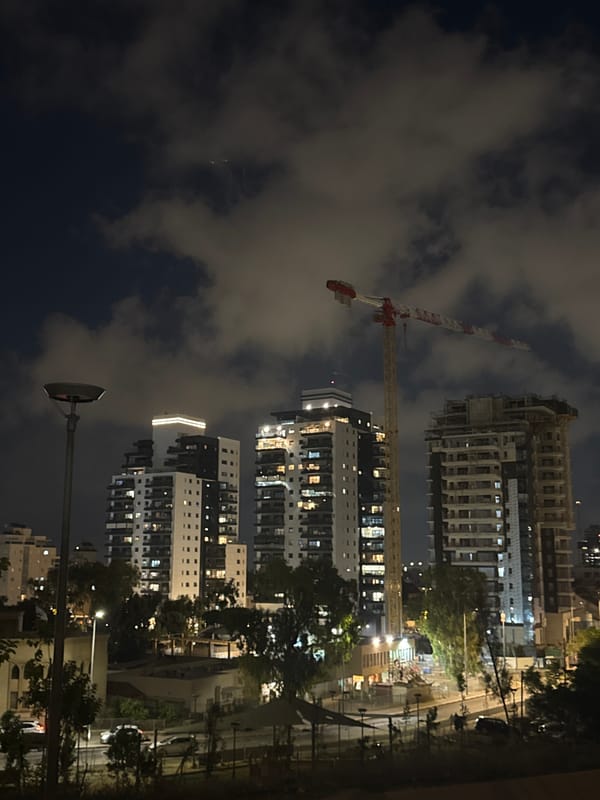 Dusk at a Netanya park, towers and cranes overhead
