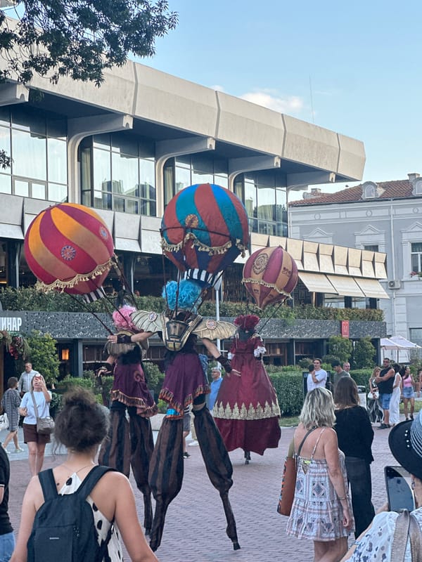Stilt performers in elaborate costumes entertain at an outdoor urban festival