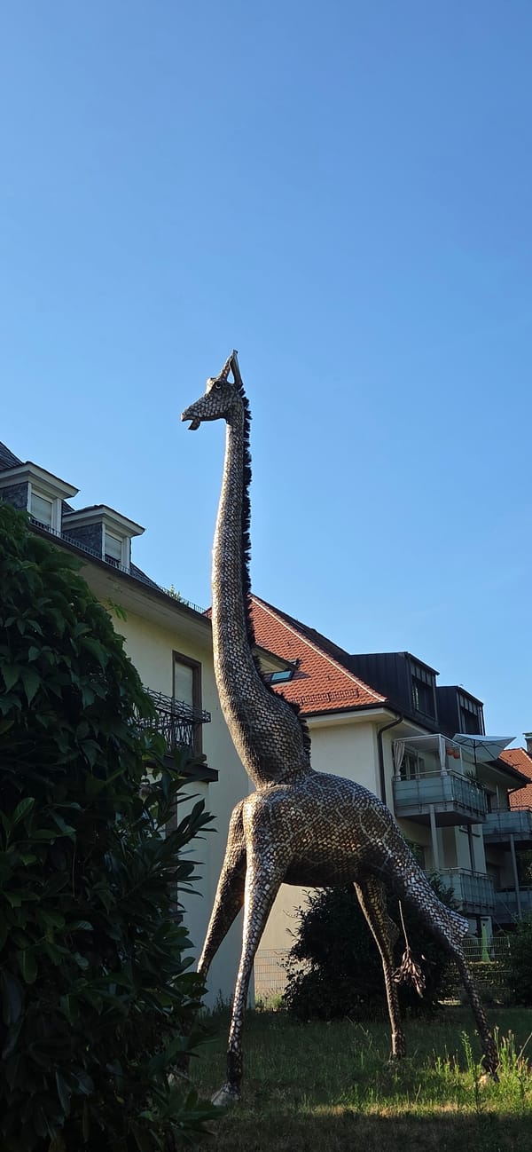 Metallic giraffe sculpture and canal at Karlsruhe Zoo