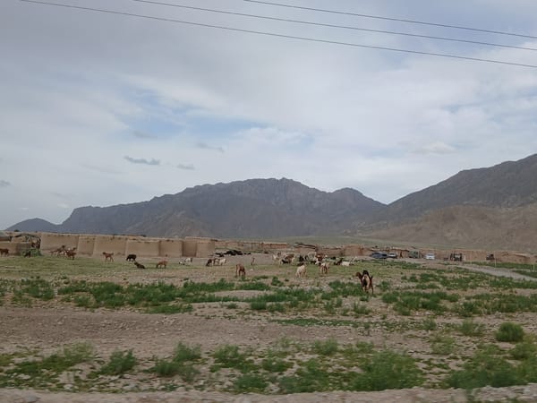 Motorcyclist travels through rural Pakistan villages amid traditional architecture