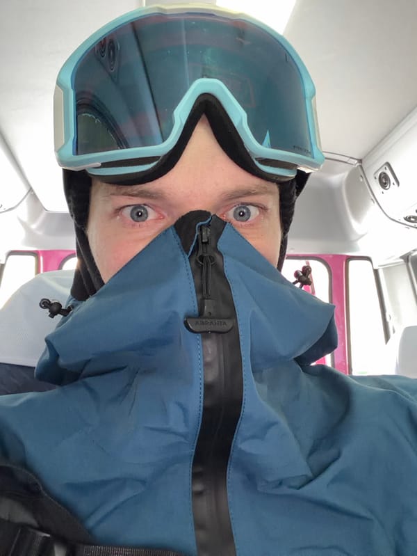 Skiers unload gear from pink van in snowy Kutchan