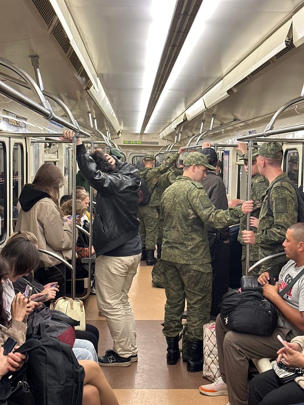Civilians and military personnel ride the Saint Petersburg Metro together