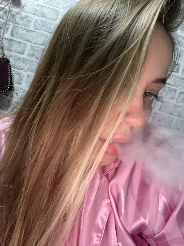 Person vaping while lying on brick surface in Russia