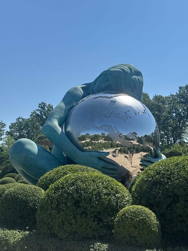 Teal globe-holding sculpture in Krasnodar's public space