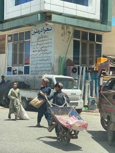 Boys with wheelbarrow seen on Kandahar street