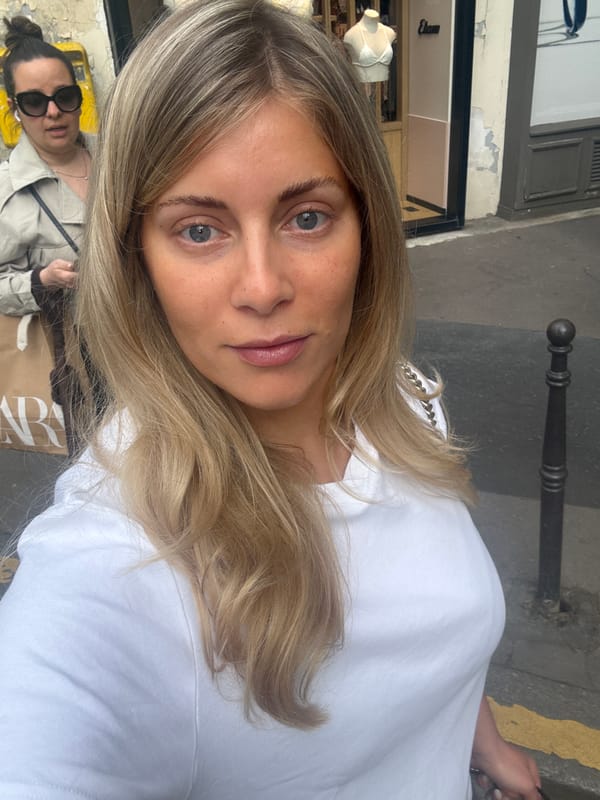 Woman takes selfie in Paris with friend in background