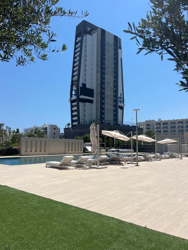 Sleek poolside setting beside a bold modern tower in Cyprus