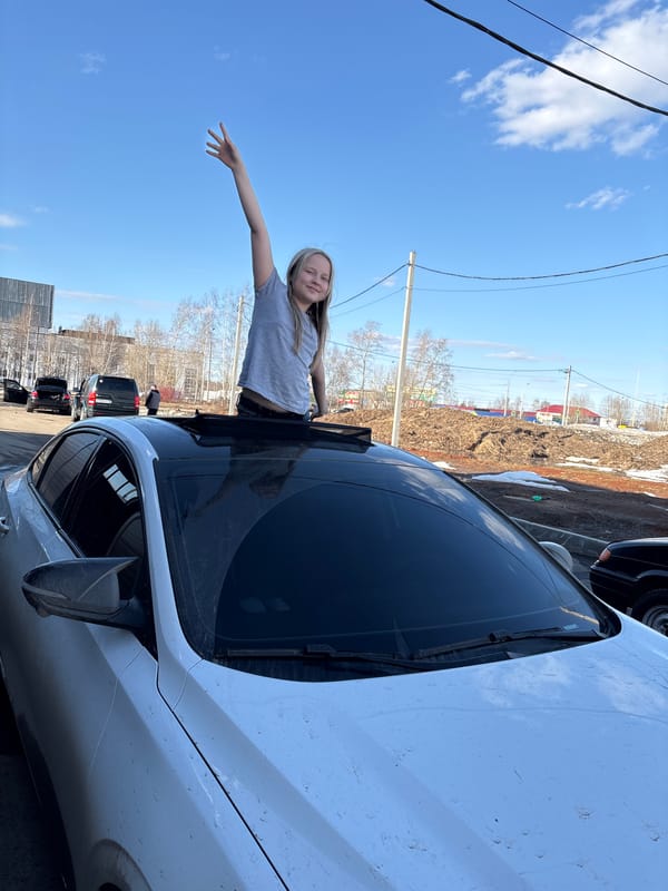 Woman poses through sunroof during car wash visit in Izhevsk