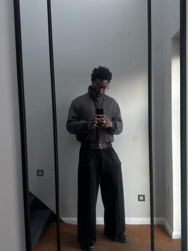 Person in herringbone jacket reflected in London mirror