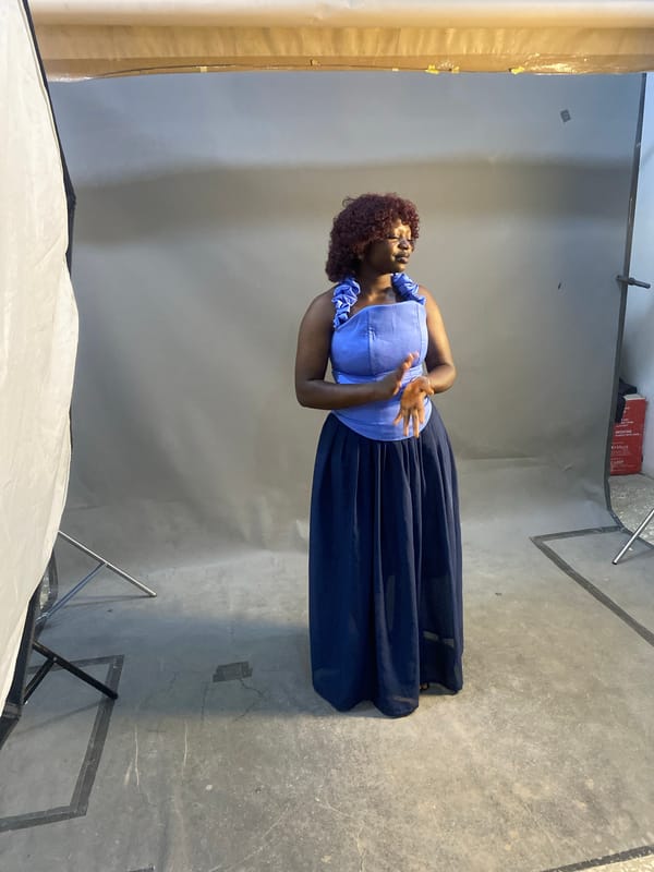 Studio portrait session in blue ruffled outfit against gray backdrop