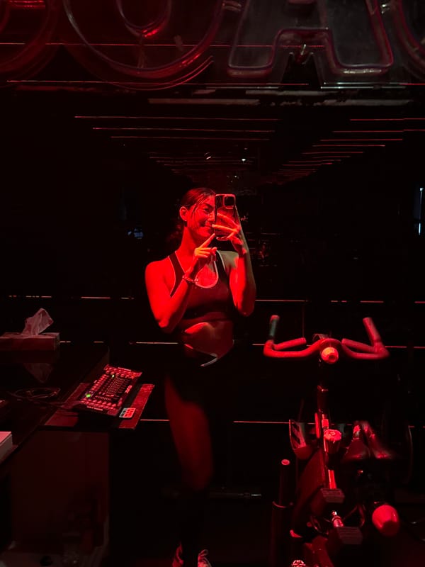 Woman poses for photos at red-lit cycling studio in Puebla