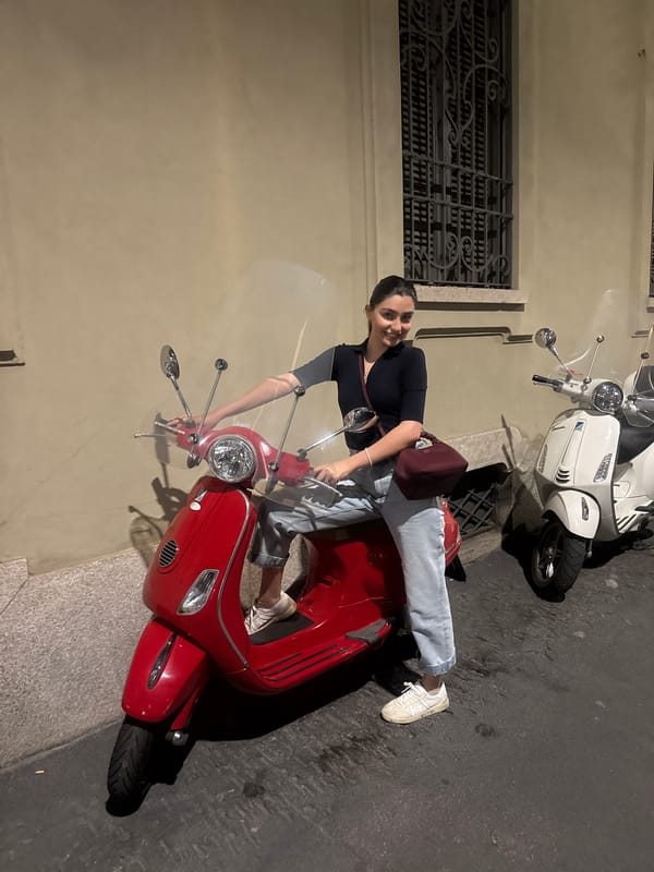 Woman poses with red Vespa on Milan street