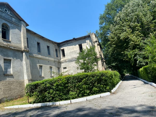 Crumbling park paths and an abandoned building in Codru, Moldova