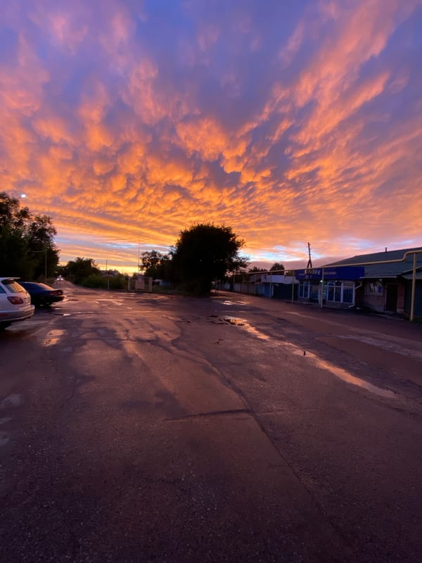 Tekeli streets glow under a fiery post-rain sunset
