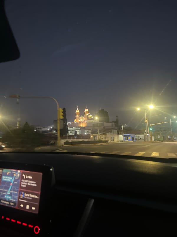 Nighttime view of illuminated Cholula church captured from vehicle