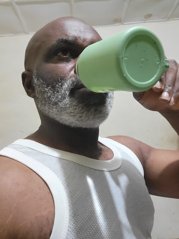 Man drinks from green cup in early morning hours
